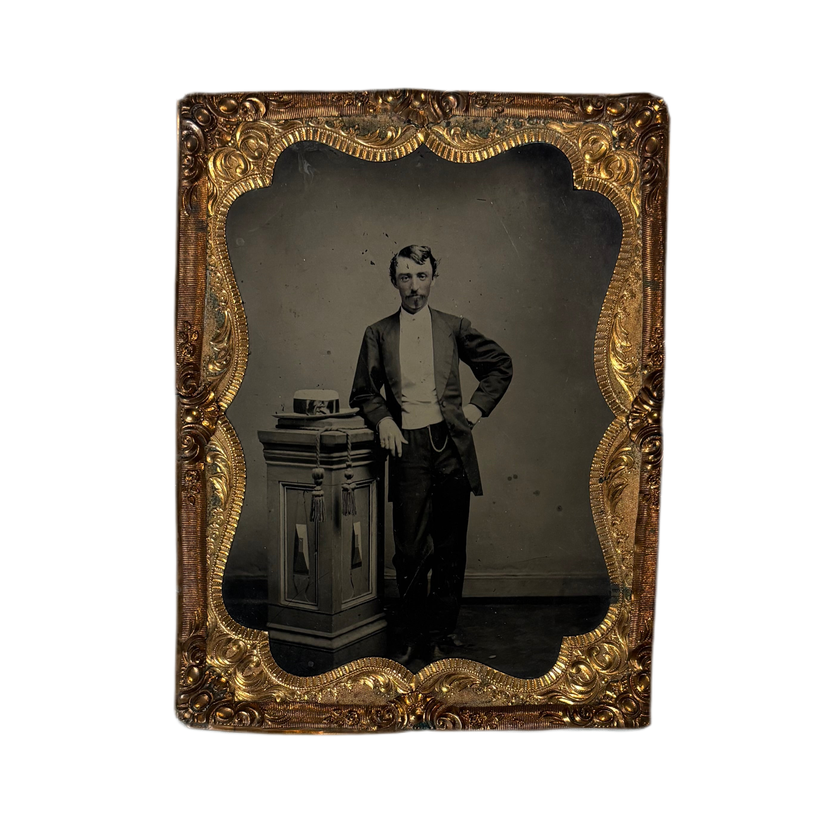 Vintage photograph of a man in a ornate gold frame on a white background